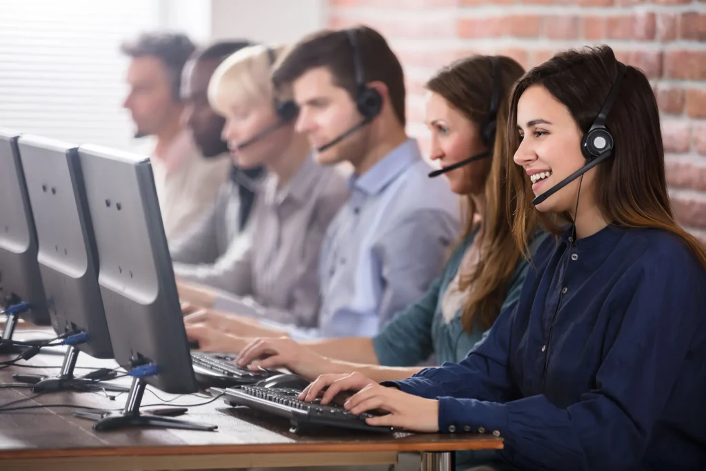 Positive Female Customer Services Agent With Headset Working In A Call Center